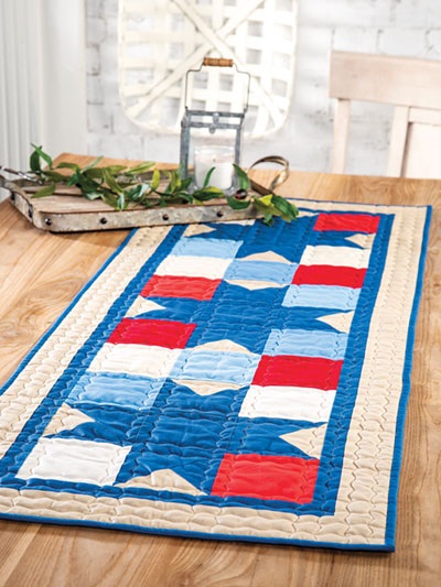 Farmhouse-style quilted table runner, from the book Farmhouse-Style Quilting, published by Annie's. Photo is courtesy of the publisher's website.
