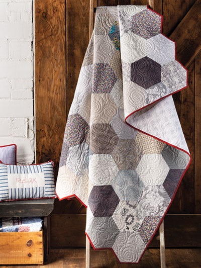 Hexagon motifs are a top trend right now. You'll find them in lots of places -- floor tiles, kitchen backsplashes -- and, best of all, in this STUNNING quilt pattern. Get your hands on a copy of Farmhouse-Style Quilting if you want the pattern and instructions for making a simple, lovely quilt just like this one (but keep in mind that you can modify the colors and textile prints if you want to customize your quilt to better match your own home decor).