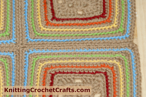 If you do the stitching with the same color yarn as the main color of your granny squares, the seam will be much less obvious. Here you can see how a completed whip stitch seam looks.
