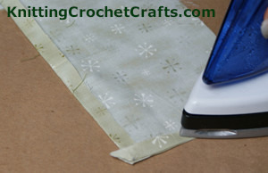 Continue pressing the seams on the lining of the checkered crochet pouch.