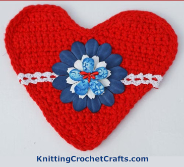 Decorate a Heart in Red, White and Blue: This version of the heart incorporates crocheted lace trim with ribbon; faux flowers; and a sparkly dragonfly-shaped gem
