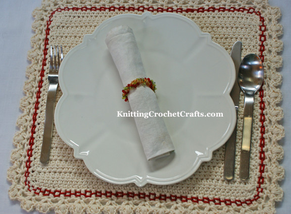 A Christmas Place Setting That Includes a Plain White Cloth Napkin Plus a Beaded Christmas Napkin Ring