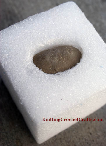 Weigh down the foam by inserting a rock or other weight into the block of craft foam.