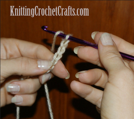 You'll work a double crochet stitch into the fourth chain stitch from your hook, which is the chain I'm indicating in this photo. See where my left thumb is pointing? That's the spot to work into.