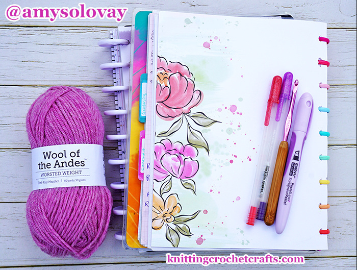 Pink Posy Heather Wool of the Andes Worsted Weight Yarn by Knit Picks, Pictured With Other Craft Supplies: My Happy Planner Notebook and Sakura Gelly Roll Pens for Writing Down My Crochet Pattern Notes; and a Susan Bates Silvalume Crochet Hook With Bamboo Handle.