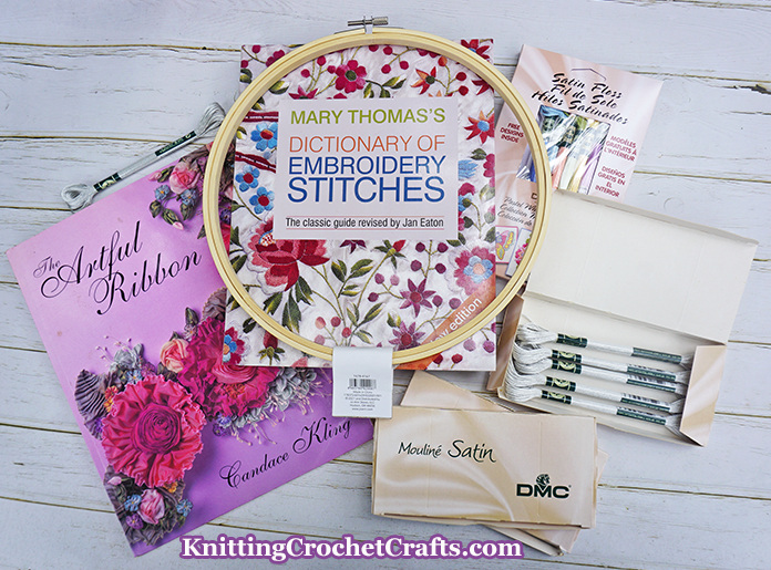 Embroidery Supplies and Pattern Books: and embroidery hoop; floss; The Artful Ribbon, which is a ribbon embroidery book; and Mary Thomas's Dictionary of Embroidery Stitches