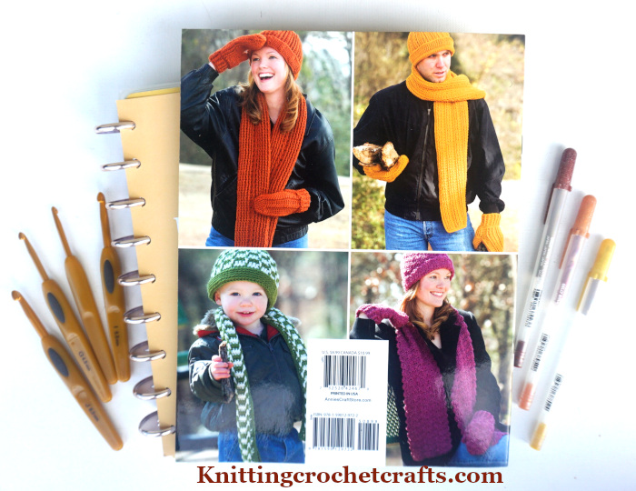 Hats, Scarves & Mittens for the Family, Pictured With Clover Soft Touch Crochet Hooks, Sakura Gelly Roll Pens and a Classic Happy Planner. These items are useful for planning your crochet projects.